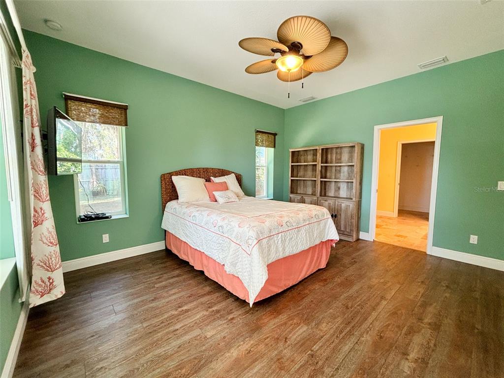 19151 Southeast 135th Court Dunnellon, FL 34431 - Photo 41 of 65 a bedroom with a large bed and a chandelier