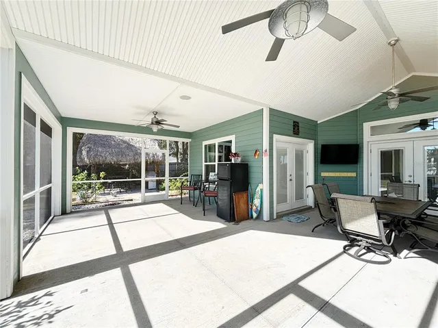 a living room with furniture a flat screen tv and a large window