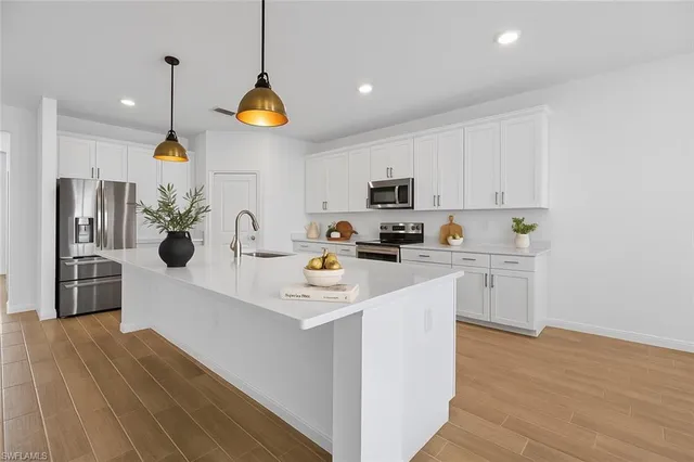 a kitchen with a sink a counter top space appliances and cabinets