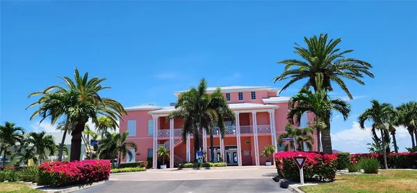 a palm tree sitting in front of a house with a yard