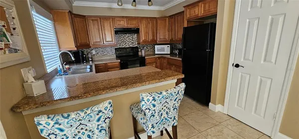 a kitchen with stainless steel appliances granite countertop a refrigerator and a stove top oven