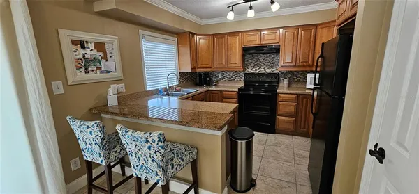a kitchen with a refrigerator and a stove top oven