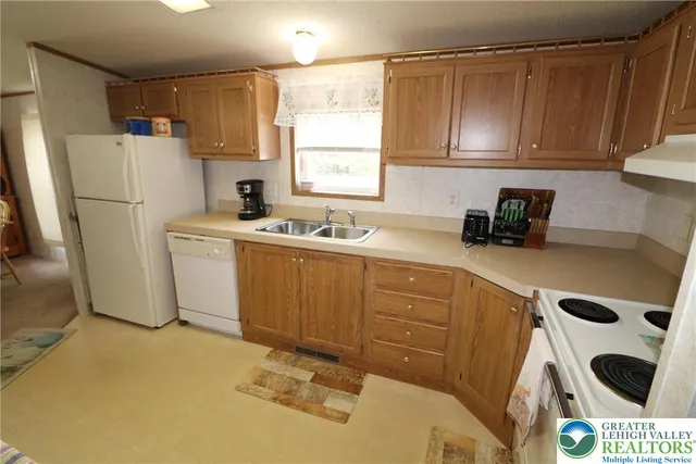 a kitchen with a sink a refrigerator and cabinets