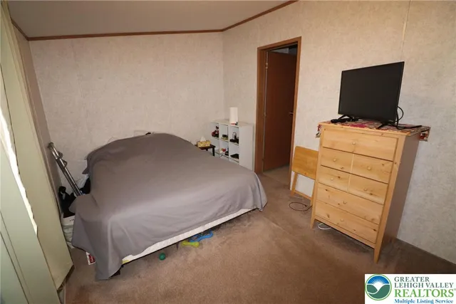 a bedroom with a bed and flat screen tv