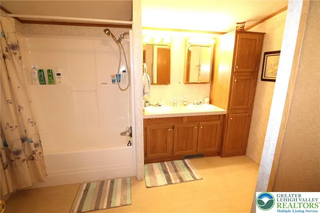 a bathroom with a sink a mirror a shower and a bathtub