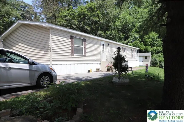 a view of a small house with a yard