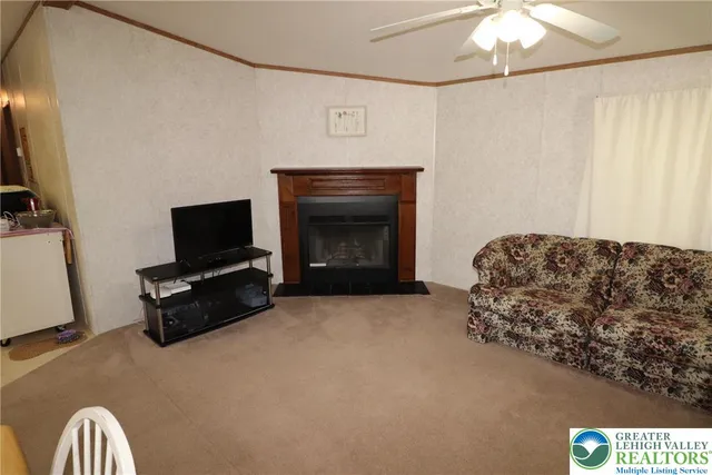 a living room with furniture a flat screen tv and a fireplace