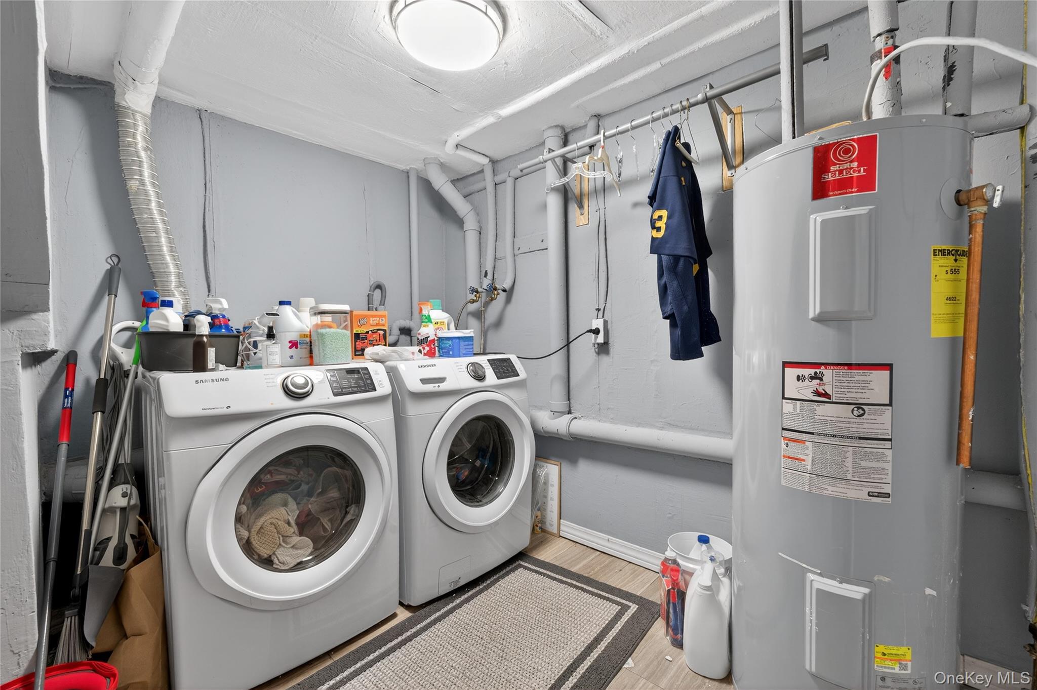 171 Melanie Way Commack, NY 11725 - Photo 24 of 29 Laundry area with electric water heater, separate washer and dryer, and wood finished floors