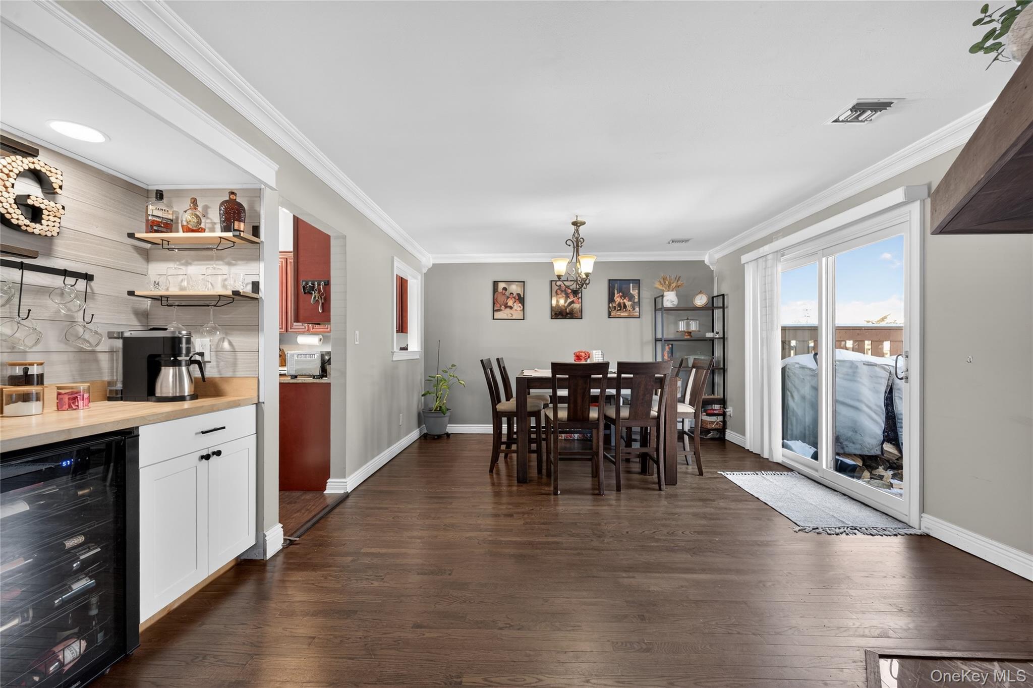 171 Melanie Way Commack, NY 11725 - Photo 3 of 29 Dining space with wine cooler, ornamental molding, dark wood finished floors, and a chandelier