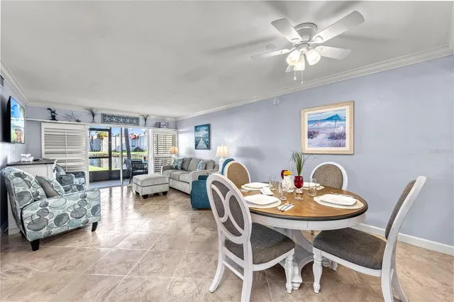 a dining room with wooden floor a chandelier fan a wooden table and chairs