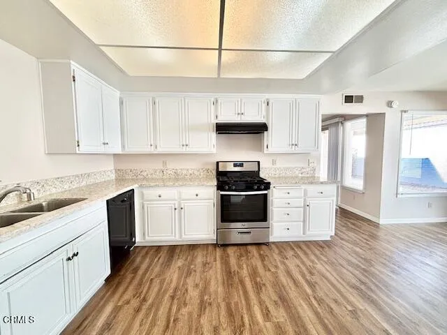 a kitchen with granite countertop white cabinets and white appliances