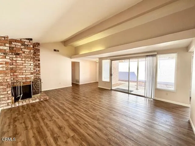 wooden floor fireplace and windows in an empty room