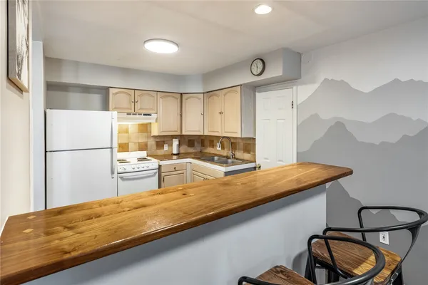 a kitchen with stainless steel appliances granite countertop a sink refrigerator and cabinets