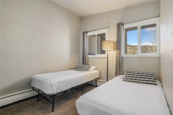 a bedroom with two beds and a window