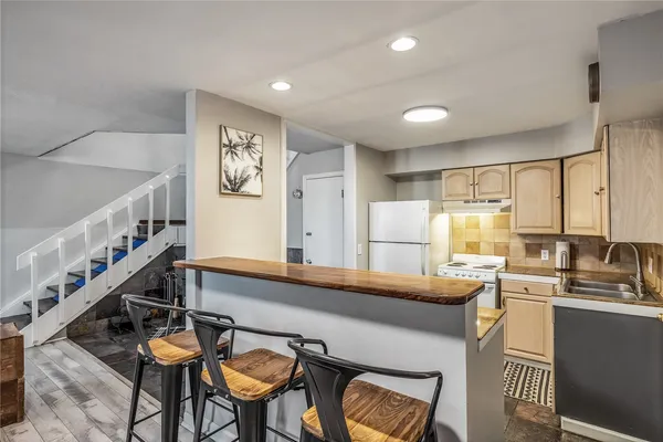 a kitchen with stainless steel appliances granite countertop a sink and a refrigerator