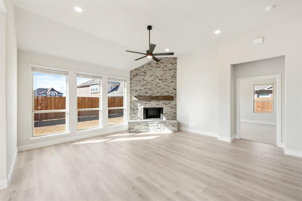 913 Firewood Way Anna, TX 75409 - Photo 20 of 40 a view of an empty room with wooden floor and a fireplace