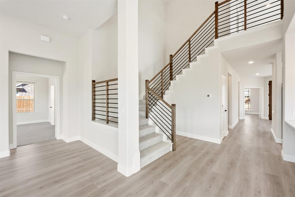 913 Firewood Way Anna, TX 75409 - Photo 25 of 40 a view of a hallway with wooden floor and staircase