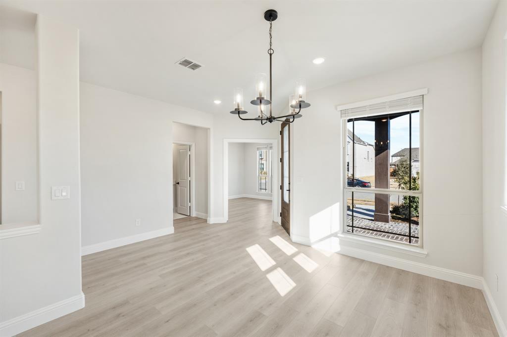 913 Firewood Way Anna, TX 75409 - Photo 6 of 40 a view of a room with wooden floor chandeliers and kitchen view