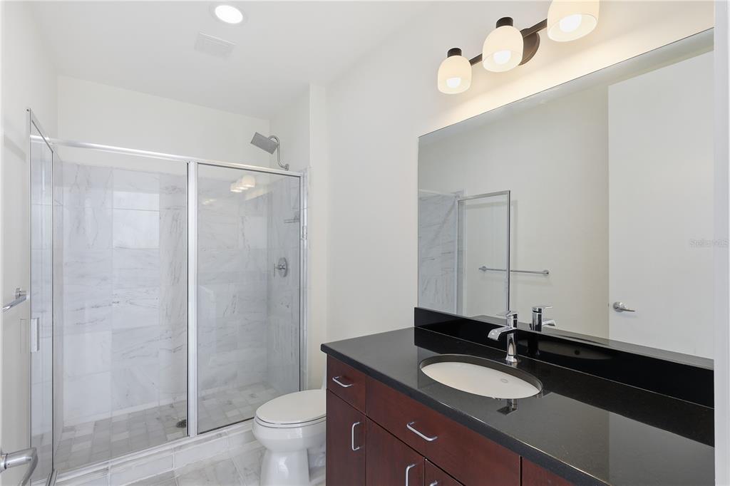 150 East Robinson Street, Unit 2002 Orlando, FL 32801 - Photo 23 of 41 a bathroom with a granite countertop sink toilet a mirror and shower
