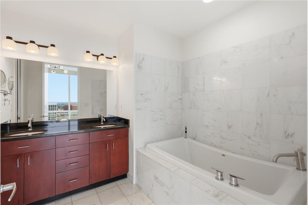 150 East Robinson Street, Unit 2002 Orlando, FL 32801 - Photo 25 of 41 a bathroom with a tub sink and mirror