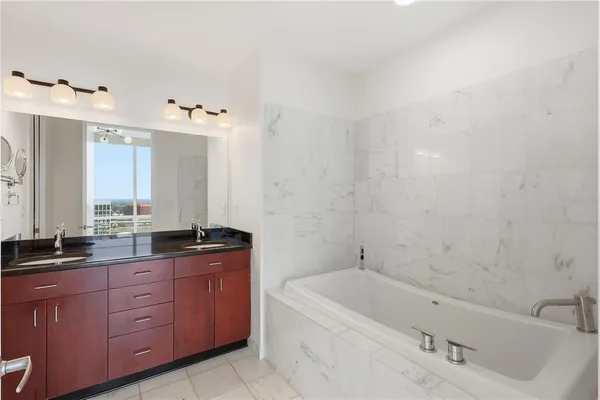 a bathroom with double vanity and a mirror