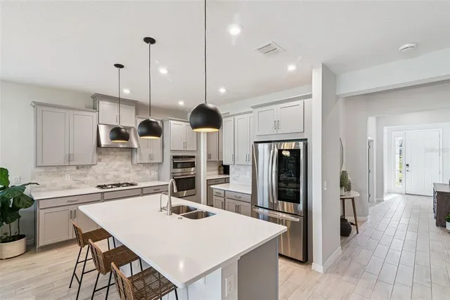 a kitchen with a sink stove and wooden floor