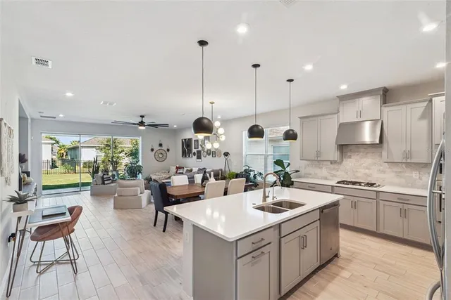 a kitchen with a table chairs stainless steel appliances and cabinets