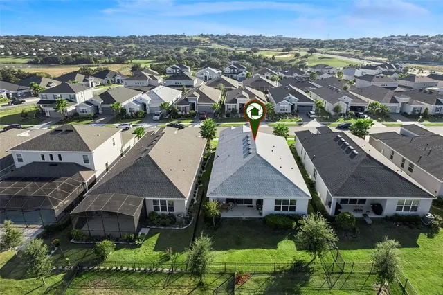 an aerial view of residential houses with outdoor space and ocean view