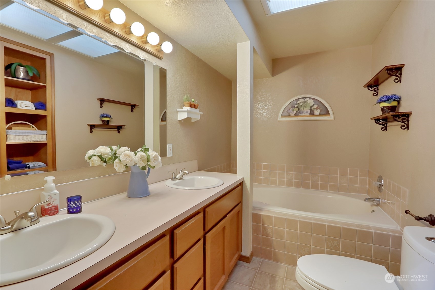 7455 Glacier Ridge Place Southeast Port Orchard, WA 98367 - Photo 22 of 32 a bathroom with a granite countertop sink mirror vanity bathtub and a toilet