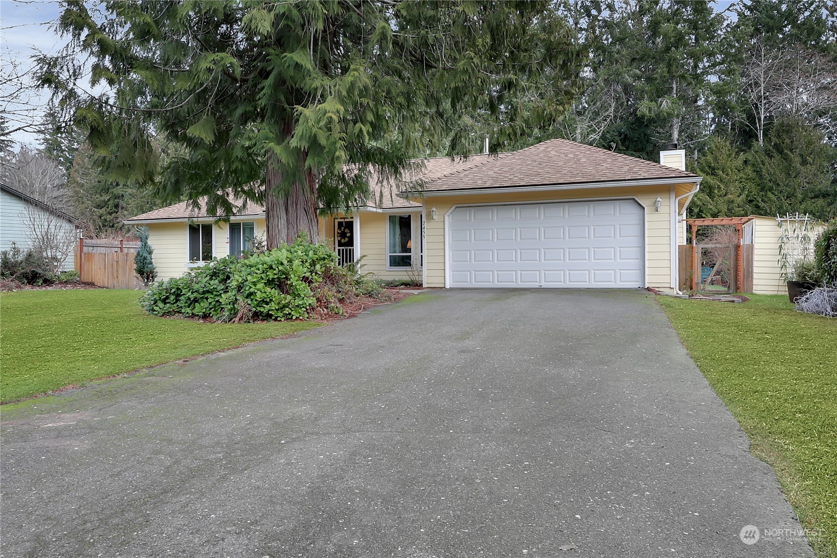 7455 Glacier Ridge Place Southeast Port Orchard, WA 98367 - Photo 4 of 32 a front view of a house with a garden and trees