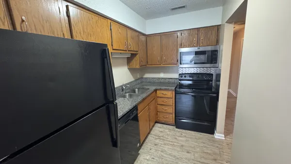 a kitchen with stainless steel appliances a refrigerator stove and microwave