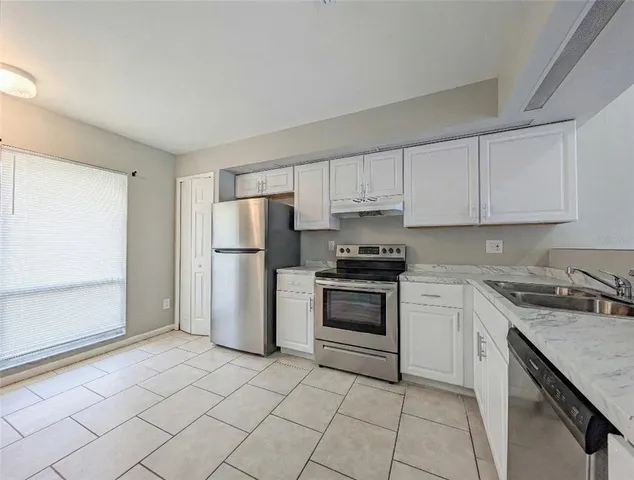 a kitchen with a stove sink and refrigerator
