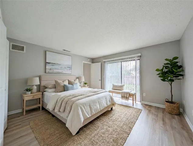 a bedroom with a large bed and a potted plant