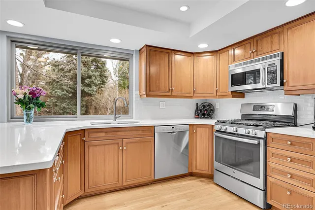 a kitchen with stainless steel appliances granite countertop cabinets wooden floor and a sink