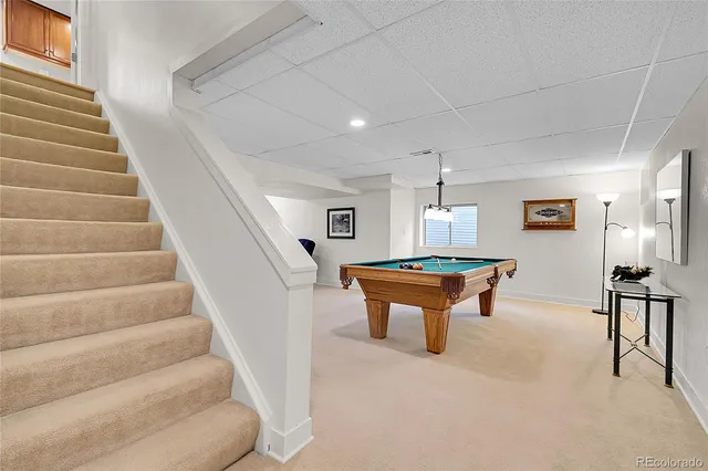 a room with pool table and windows