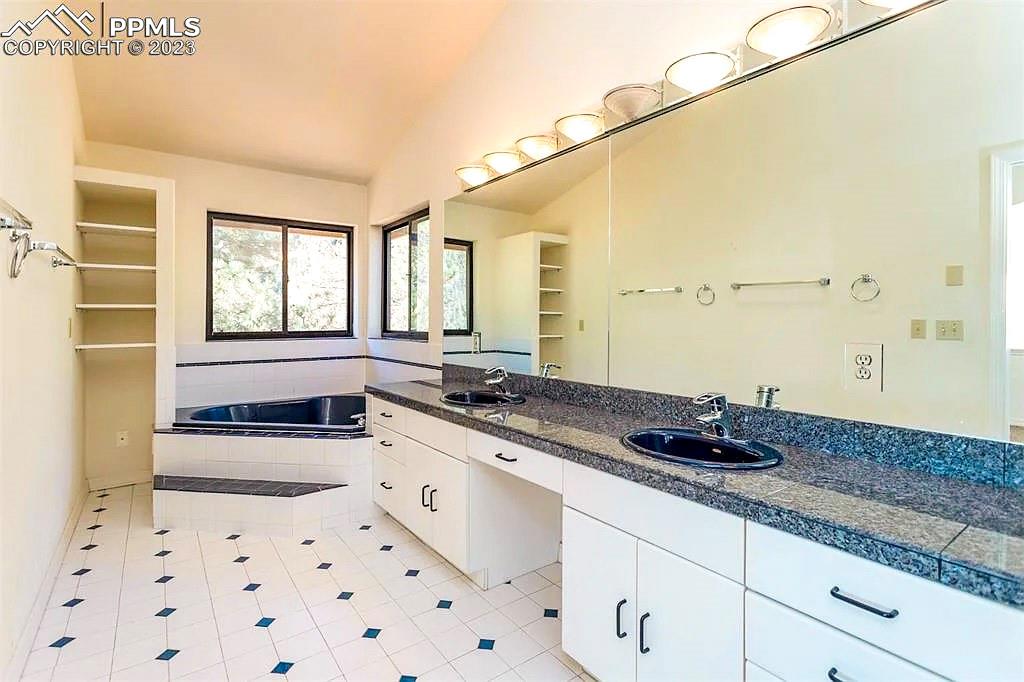 4440 Prairie Street Cascade, CO 80809 - Photo 14 of 31 a bathroom with a granite countertop sink a mirror and a bathtub