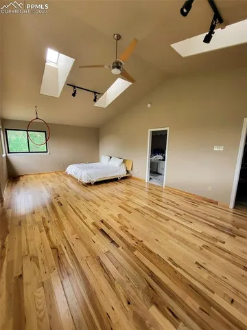 a spacious bedroom with a large bed and a chandelier