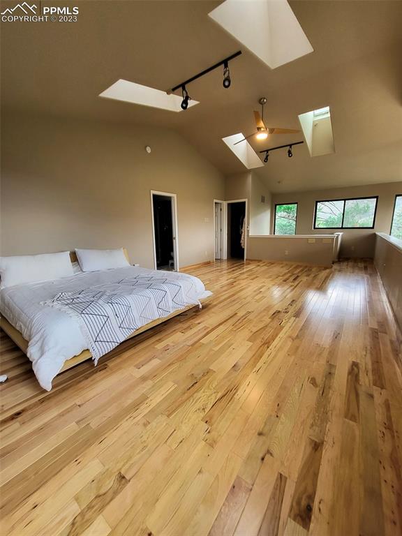4440 Prairie Street Cascade, CO 80809 - Photo 20 of 31 a spacious bedroom with a large bed and a chandelier