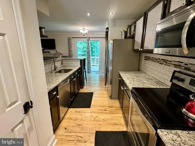 a kitchen with stainless steel appliances granite countertop a table and chairs