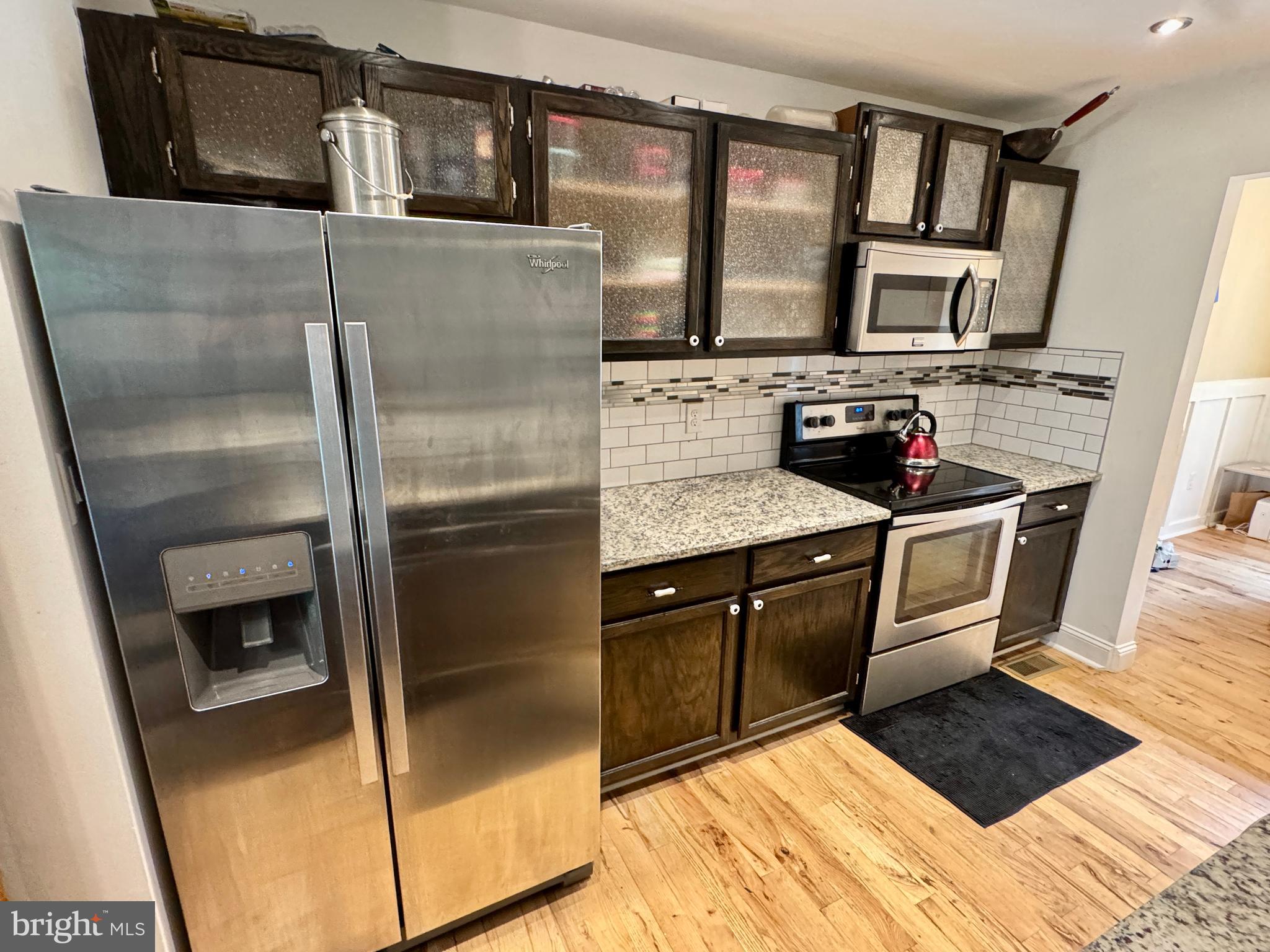 903 Wind Ridge Drive Stafford, VA 22554 - Photo 8 of 34 a kitchen with stainless steel appliances granite countertop a refrigerator a stove and a sink with wooden floor