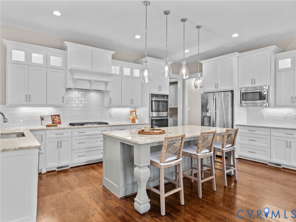 16125 Binley Road Midlothian, VA 23112 - Photo 17 of 50 a kitchen with stainless steel appliances kitchen island granite countertop a wooden floor and white cabinets