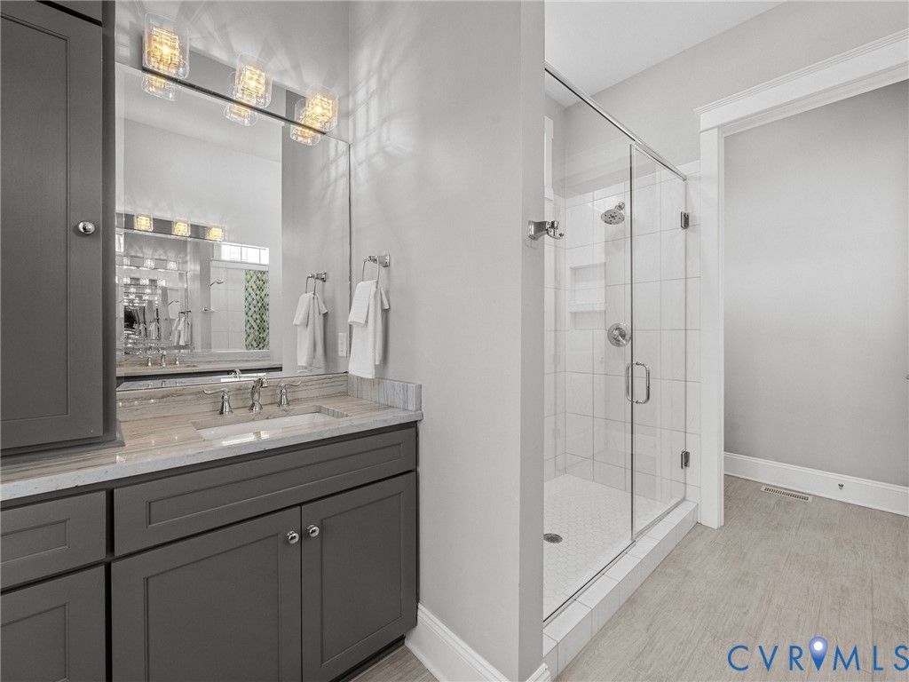 16125 Binley Road Midlothian, VA 23112 - Photo 29 of 50 a bathroom with a granite countertop sink a mirror and a shower