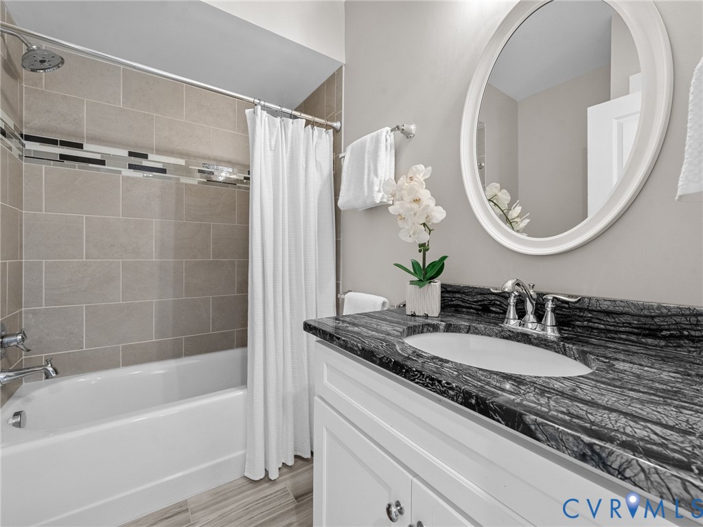16125 Binley Road Midlothian, VA 23112 - Photo 41 of 50 a bathroom with a granite countertop sink a mirror and a bathtub