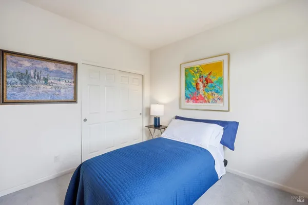 a bedroom with a bed and painting on the wall