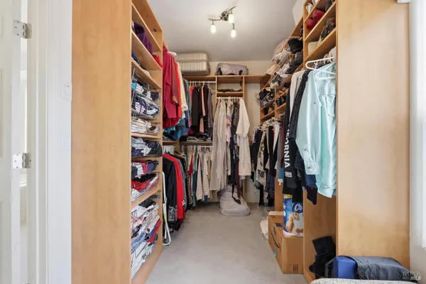 a view of walk in closet with clothes