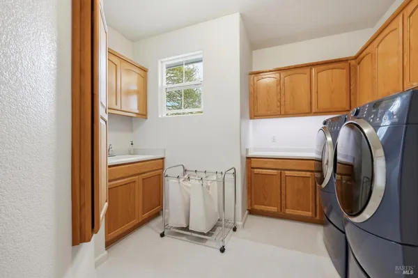 a utility room with sink dryer and washer