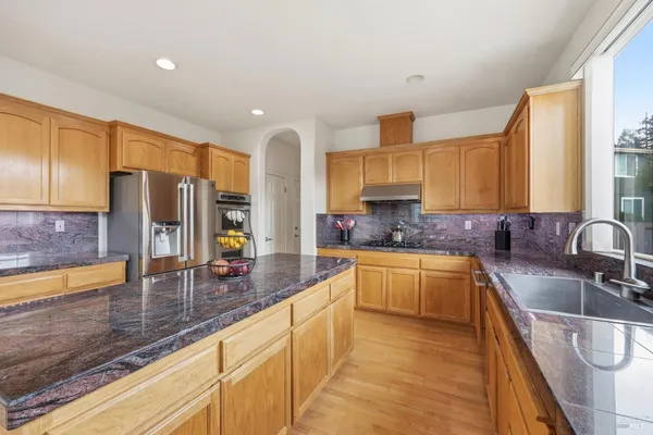 a kitchen with stainless steel appliances granite countertop a sink stove and cabinets