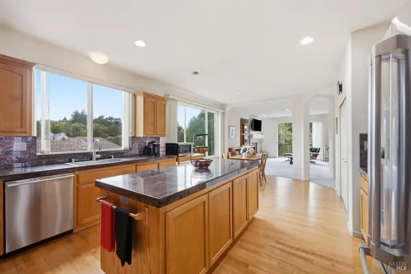 a large kitchen with stainless steel appliances a lot of counter space and a wooden floor