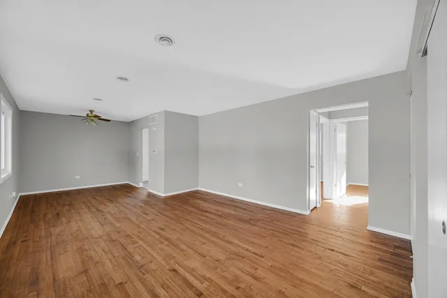 a view of an empty room with wooden floor
