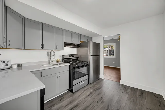 a kitchen with a sink cabinets stainless steel appliances and a window